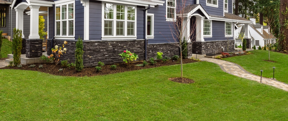 A blue house in Stephens City, VA with a healthy green lawn thanks to our team.