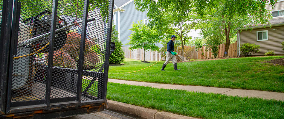 A professional is spraying lawn fertilizer over a lawn.